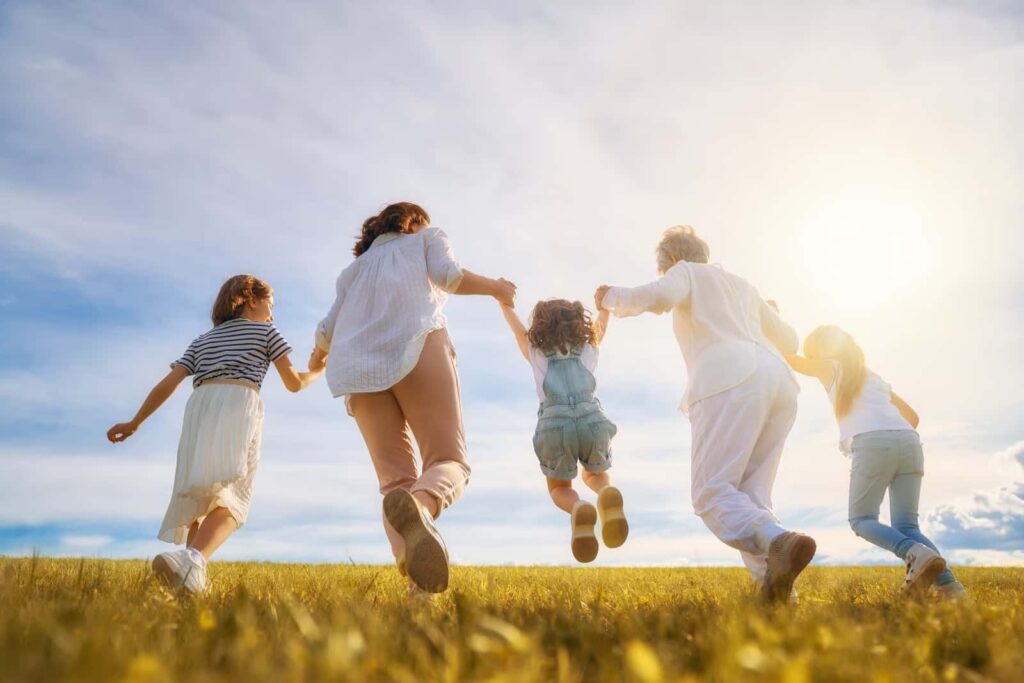 Familia feliz en un campo abierto saltando