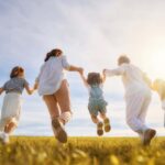Familia feliz en un campo abierto saltando
