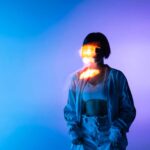 Imagen conceptual con una persona iluminada por luces azules y violetas, ideal para representar la diferencia entre la teoría y la realidad en los cursos y procesos de formación.