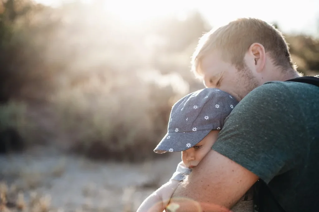Padre abrazando a su hijo al atardecer para reparar el vínculo después de un enfado