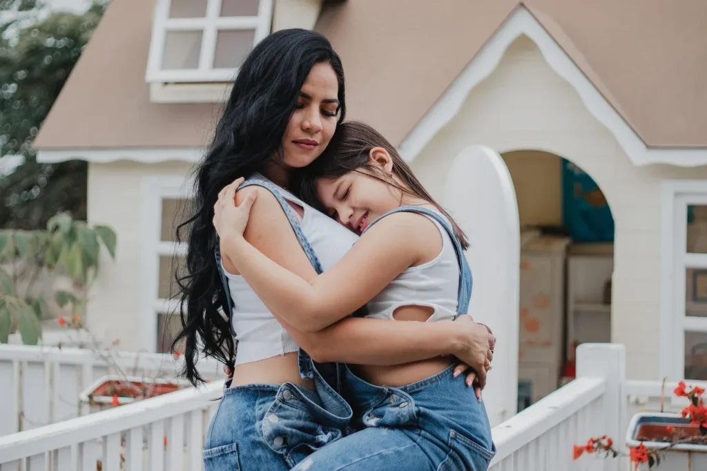 Madre abrazando a su hija para reparar el vínculo después de un grito