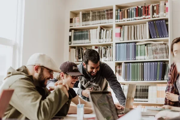 Estudiantes sonriendo mientras revisan juntos un curso online de Crece con Amor