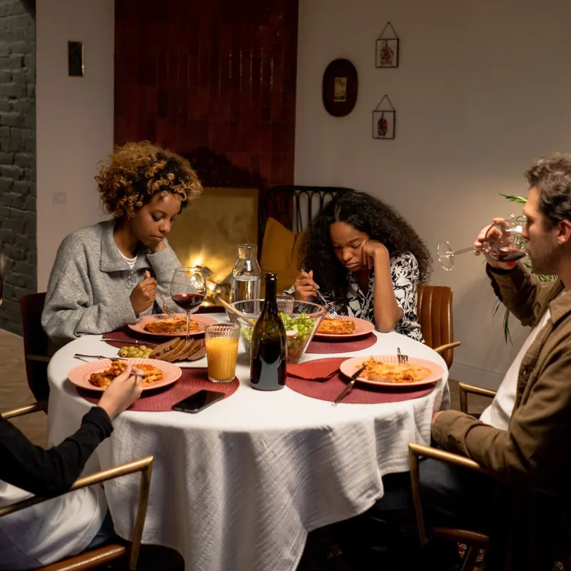 Familia cenando en silencio, cada uno a lo suyo, cuando cuesta que tus hijos te escuchen